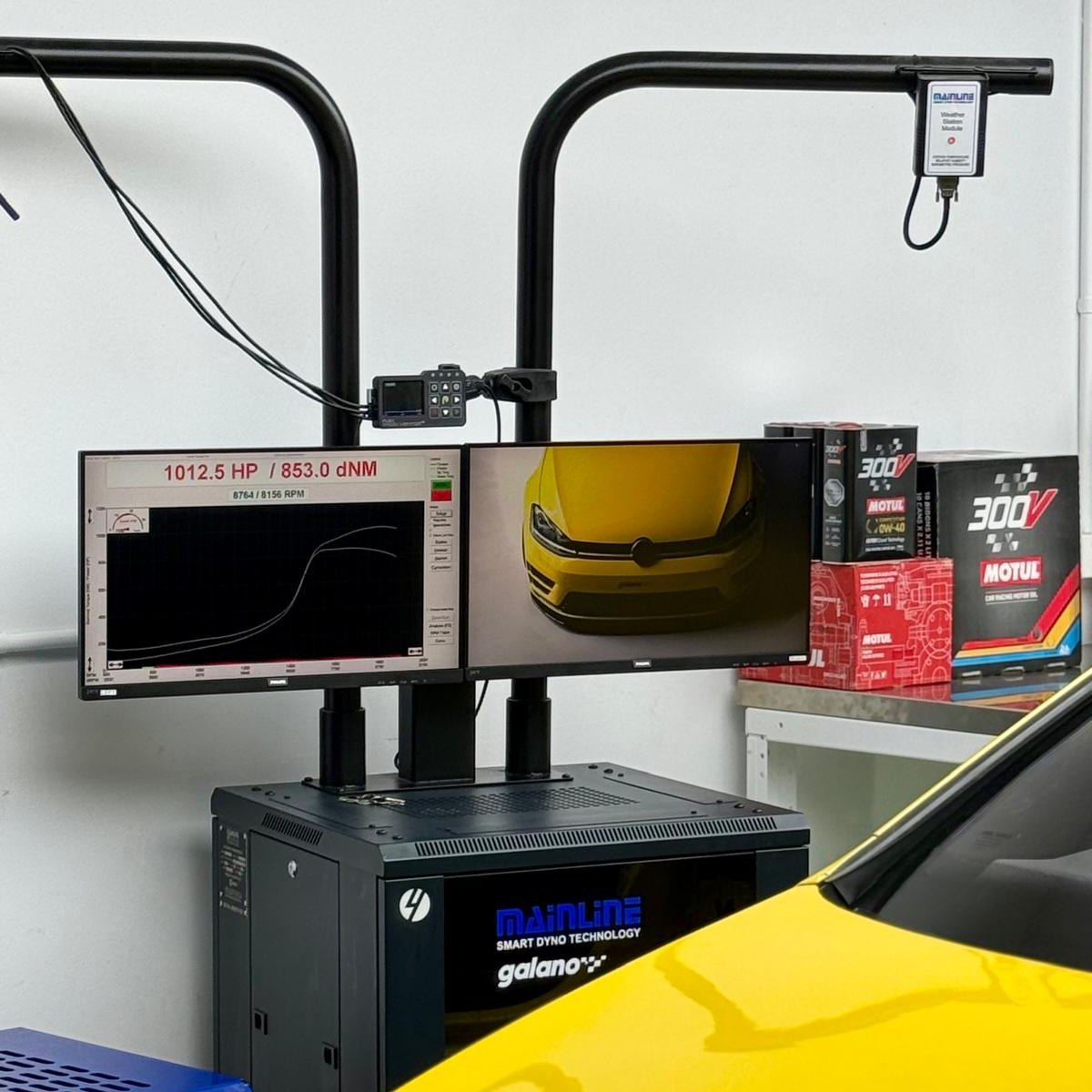 Atelier Galano avec un écran de mesure et une voiture jaune